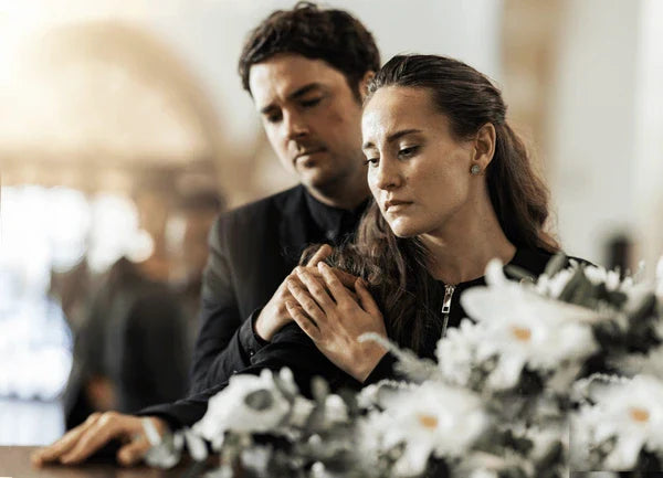 Man comforts woman at funeral